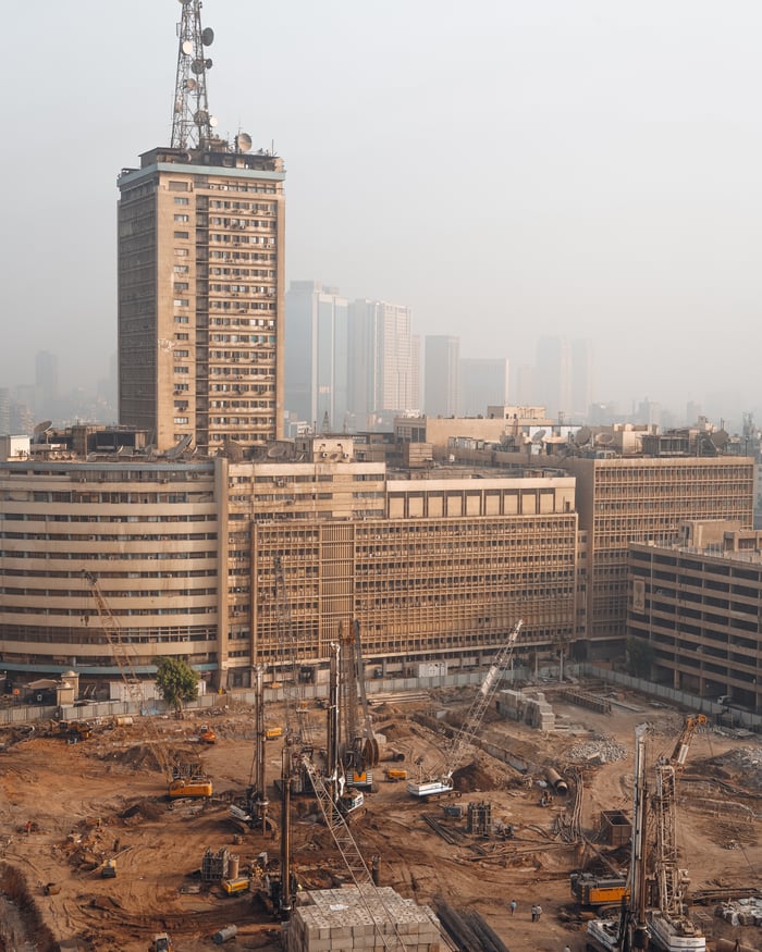 gallery-2 Aerial view of Cairo construction site with hazy skyline and high-rise buildings in Egypt.