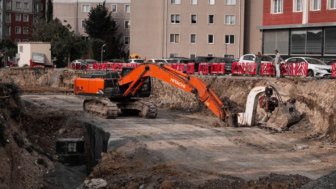 our-experience Excavators operating at an urban construction site, surrounded by residential buildings.
